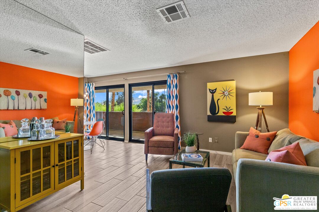 a living room with furniture a window and a flat screen tv