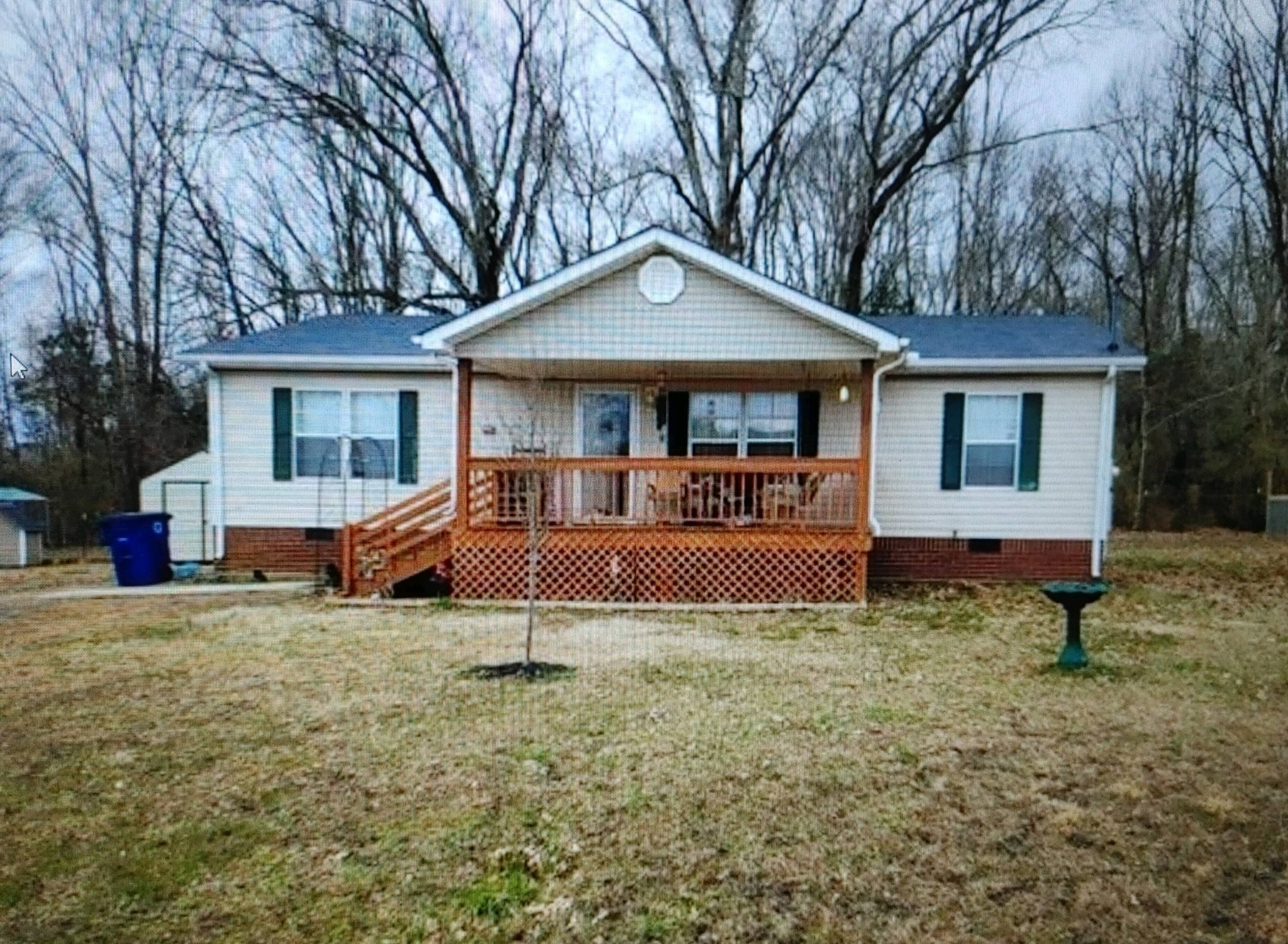 a view of a house with a yard and large tree