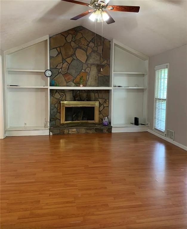 a view of a room with wooden floor and a fireplace