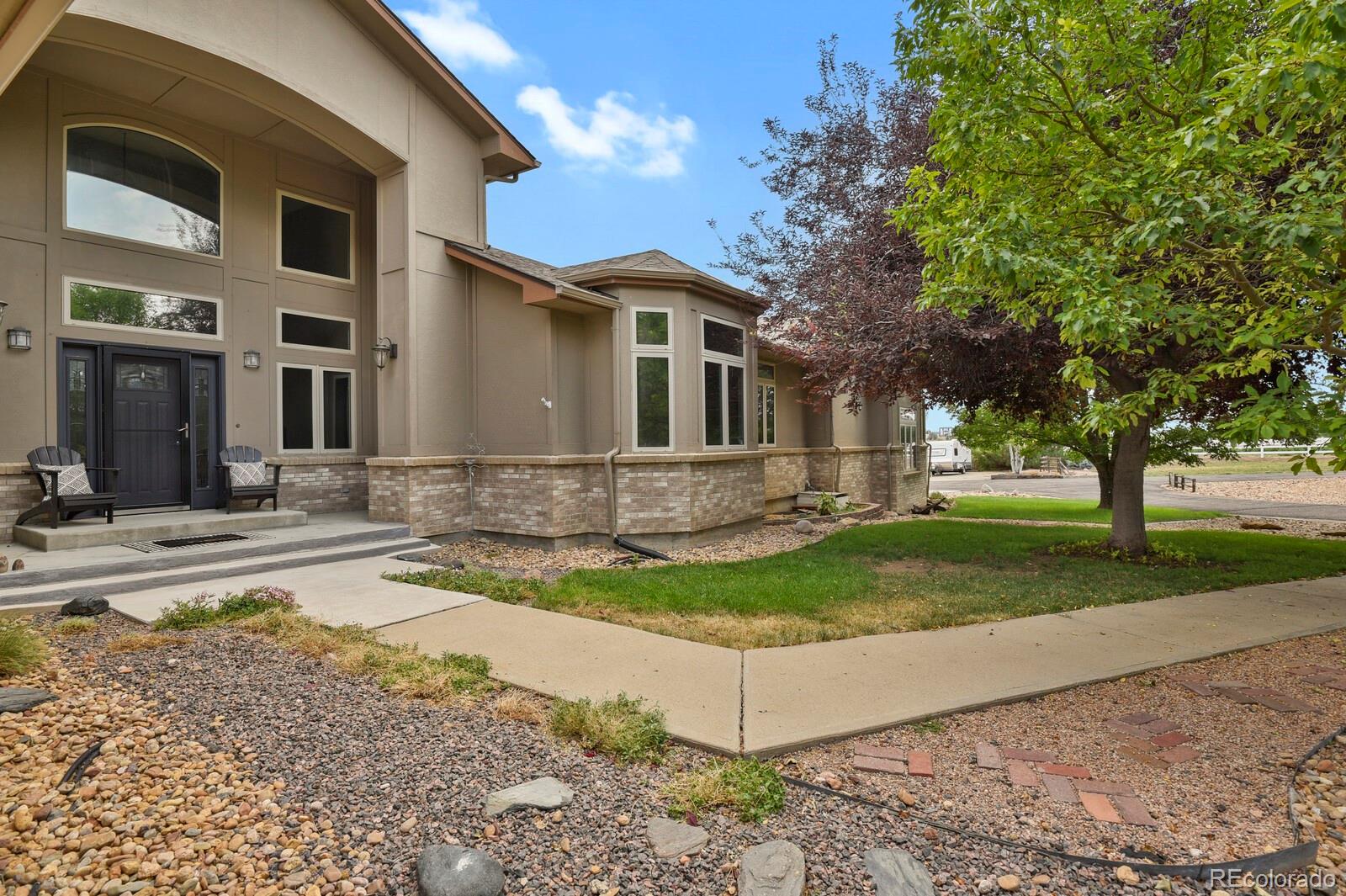 a front view of a house with a yard and trees