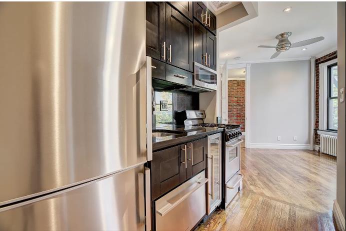 a kitchen with stainless steel appliances granite countertop a refrigerator and a stove top oven