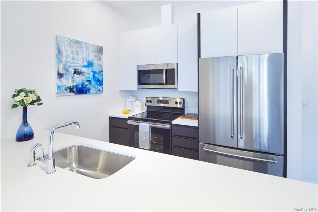 a kitchen with a refrigerator sink and white cabinets