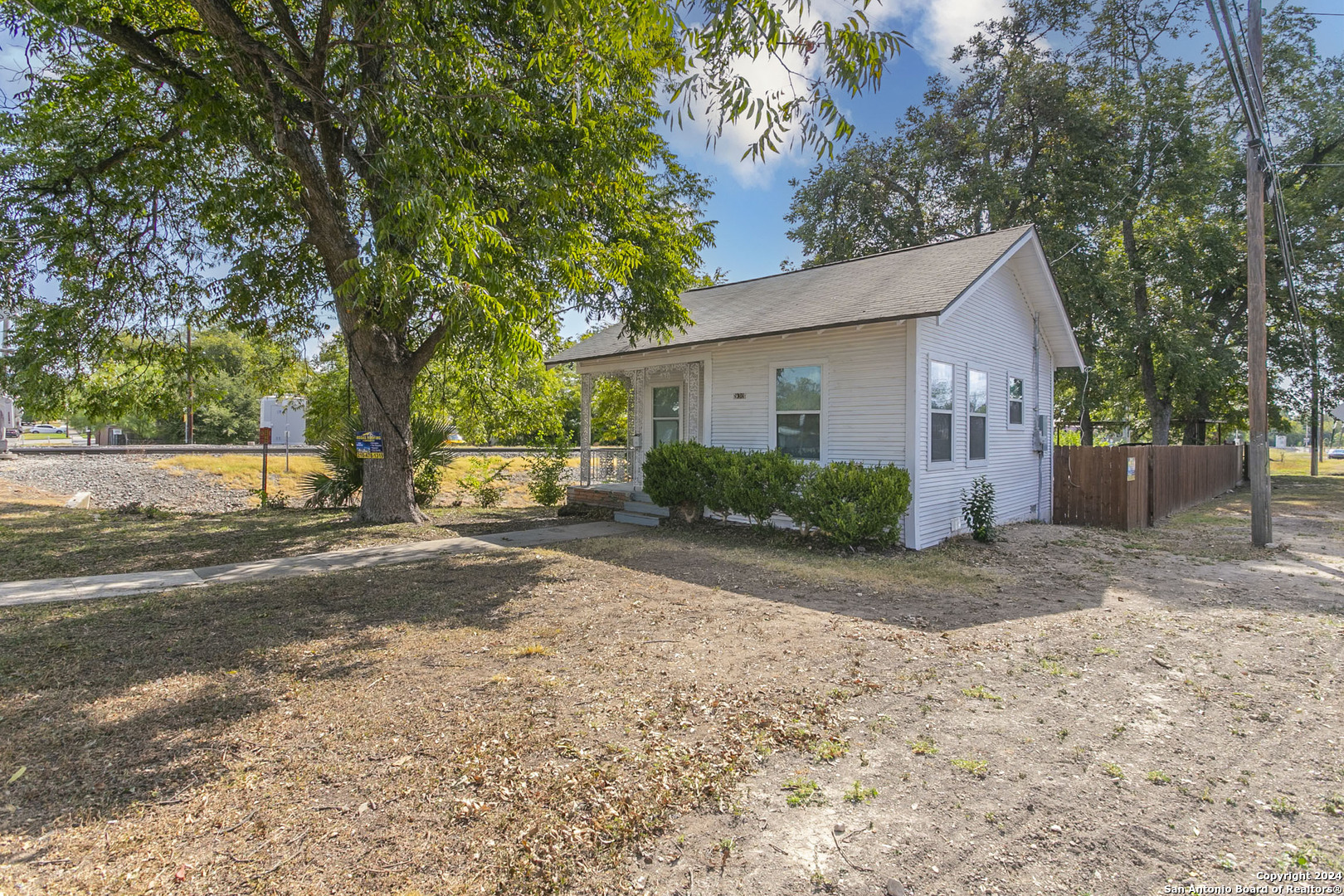 a view of a house with a yard and large tree