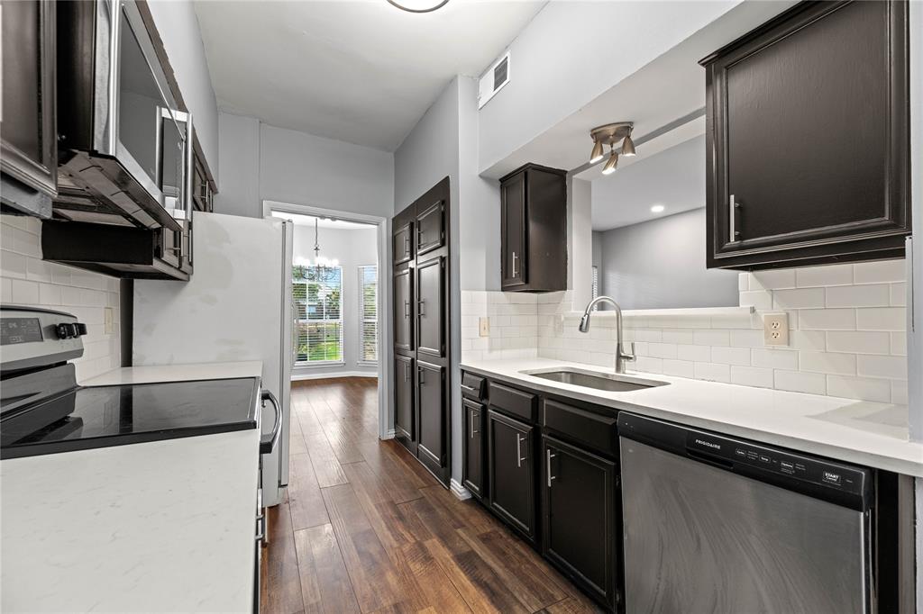 a kitchen with stainless steel appliances granite countertop a sink stove and refrigerator