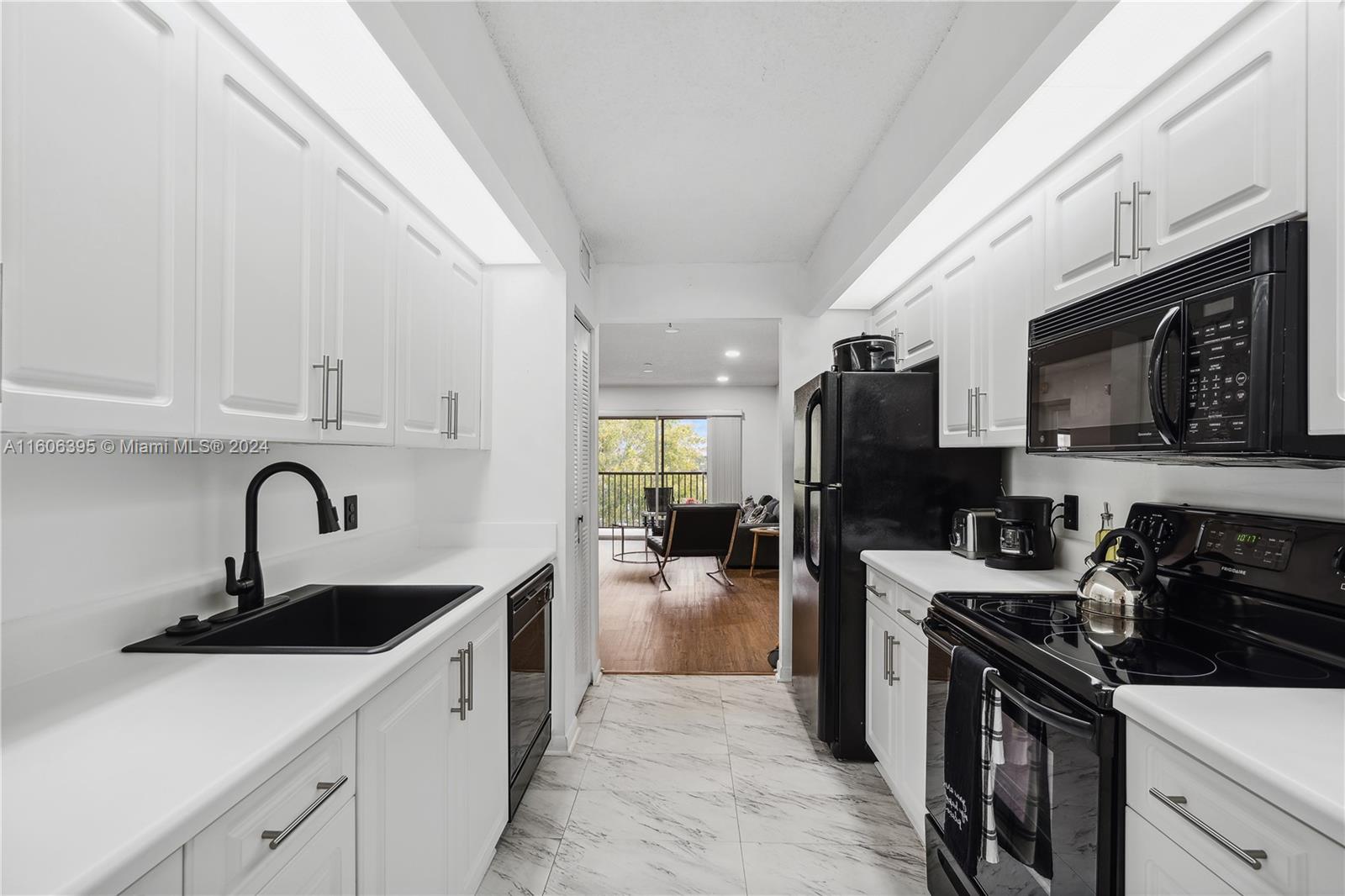 a kitchen with a sink stainless steel appliances and white cabinets