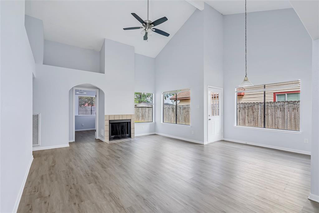 a view of a livingroom with a fireplace wooden floor and windows