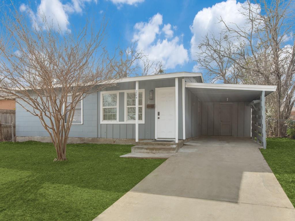 a front view of a house with a garden and trees