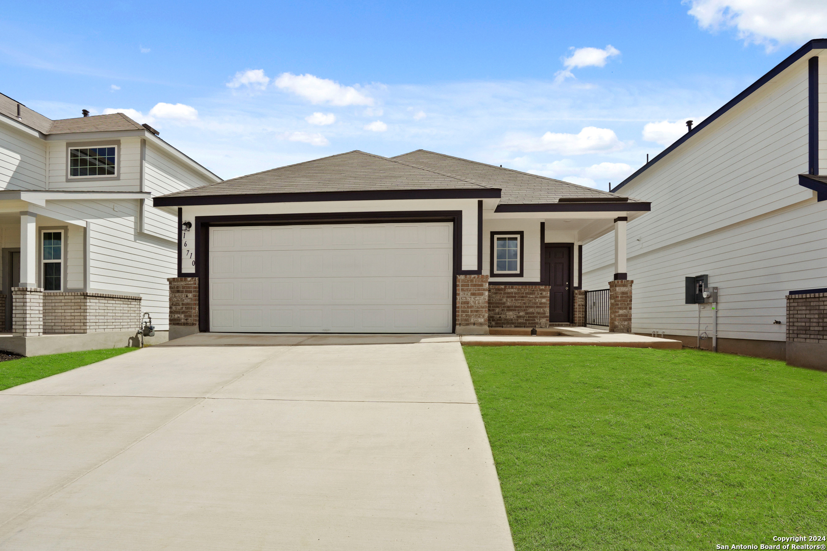 a front view of a house with a yard and garage