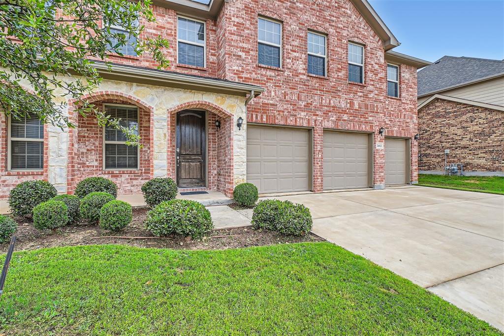 front view of a brick house with a yard