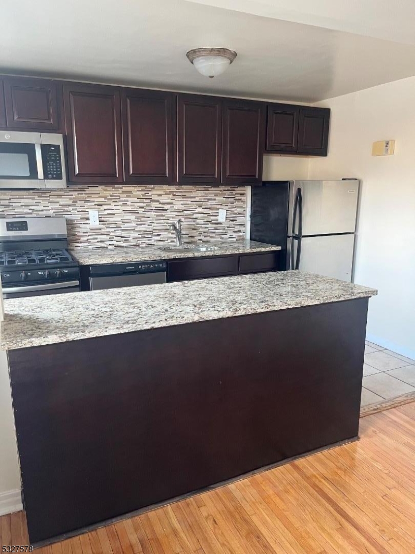 a kitchen with granite countertop cabinets a sink and dishwasher