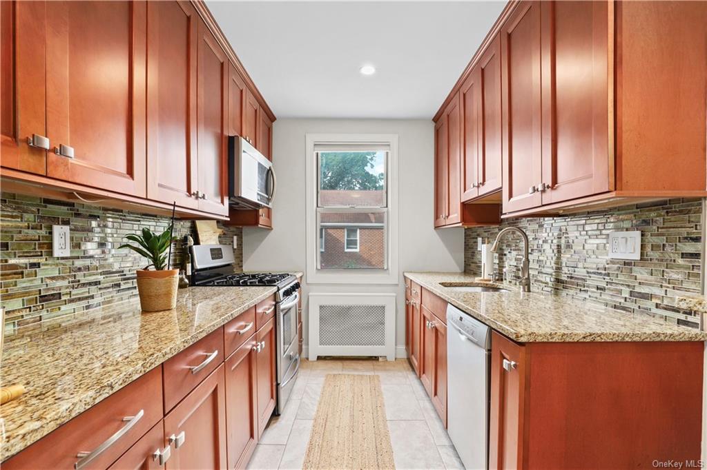 a kitchen with stainless steel appliances granite countertop a sink a stove and cabinets