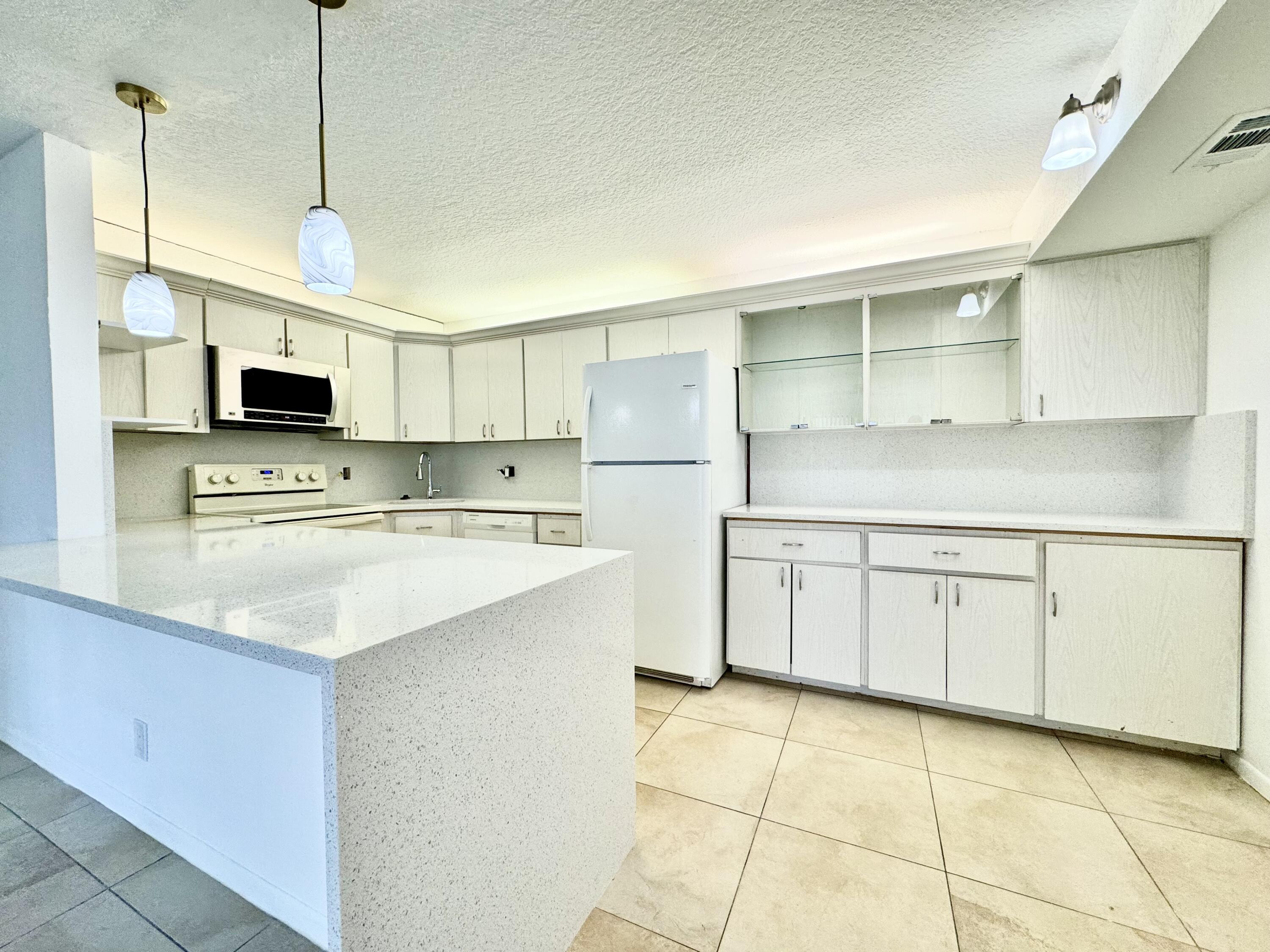 a kitchen with stainless steel appliances granite countertop a sink a stove and a refrigerator