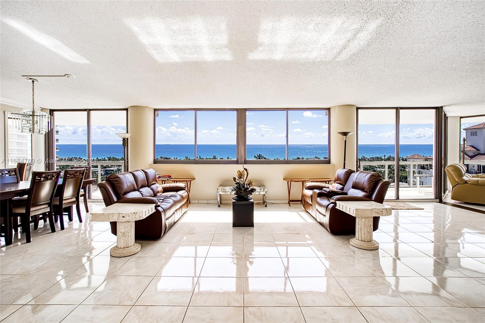 a living room with furniture and floor to ceiling windows