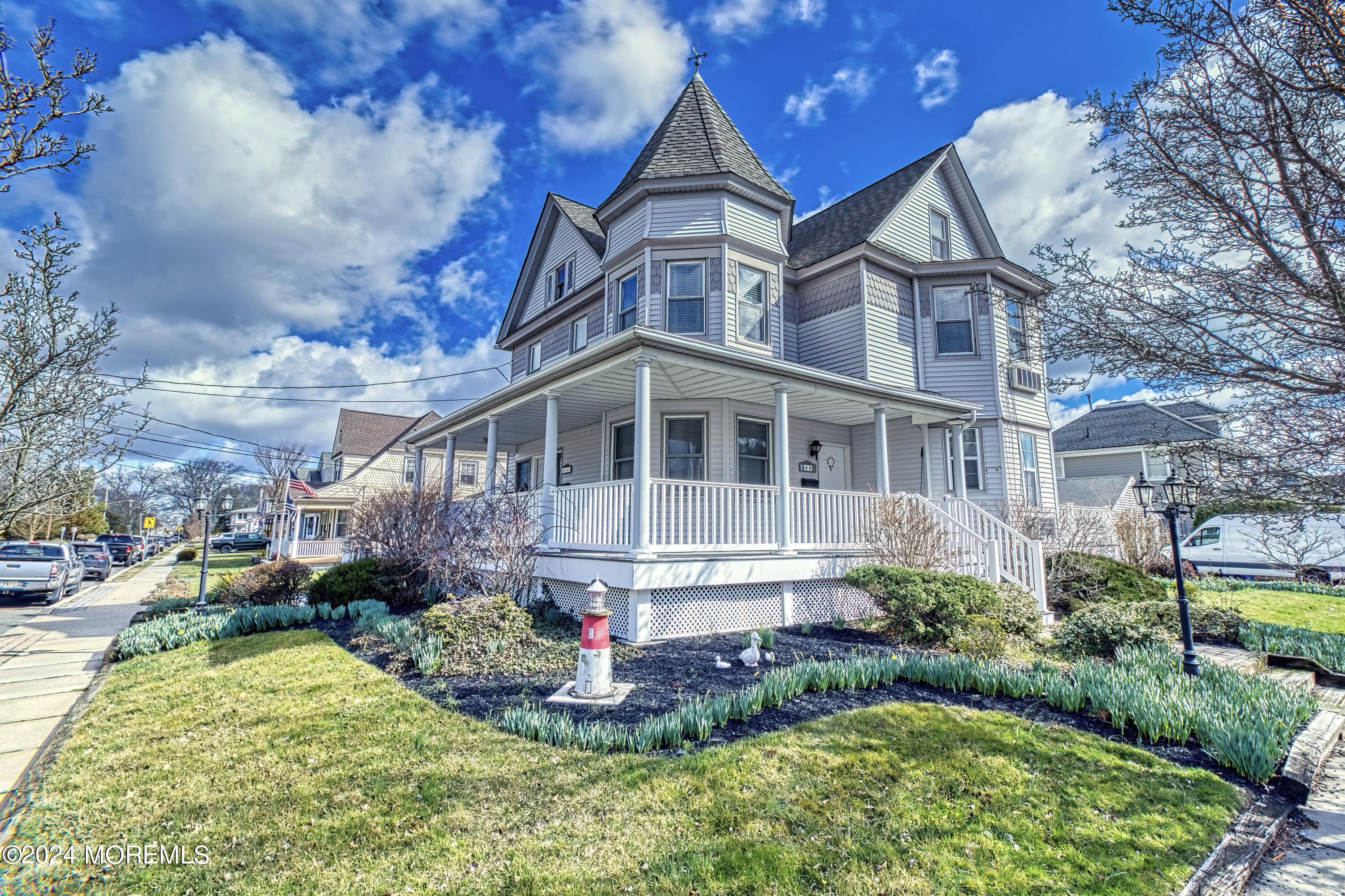 a front view of a house with a yard and potted plants