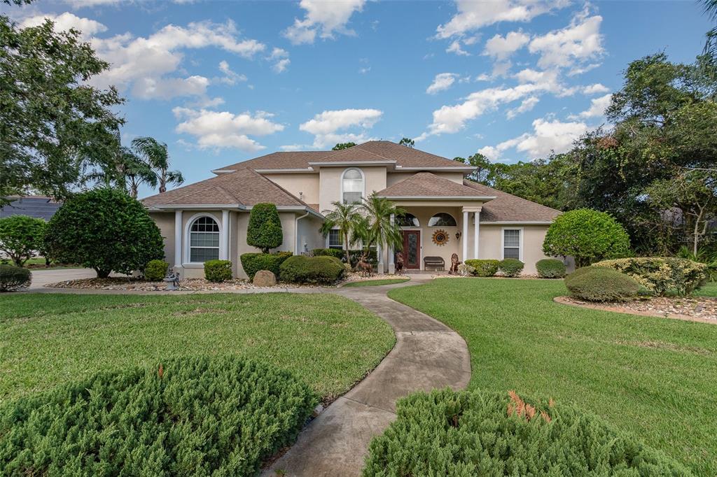 a view of a house with backyard sitting area and garden