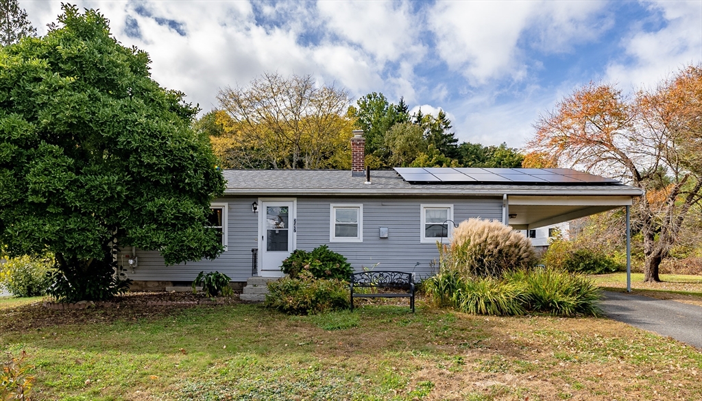 a front view of house with yard and trees around