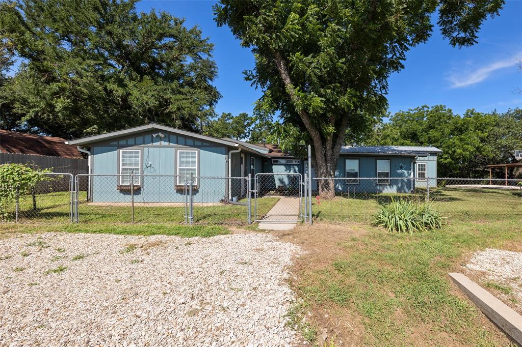 a view of a house with a yard and large tree