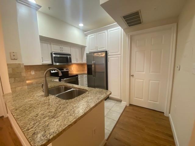 a kitchen with kitchen island granite countertop a sink refrigerator and microwave