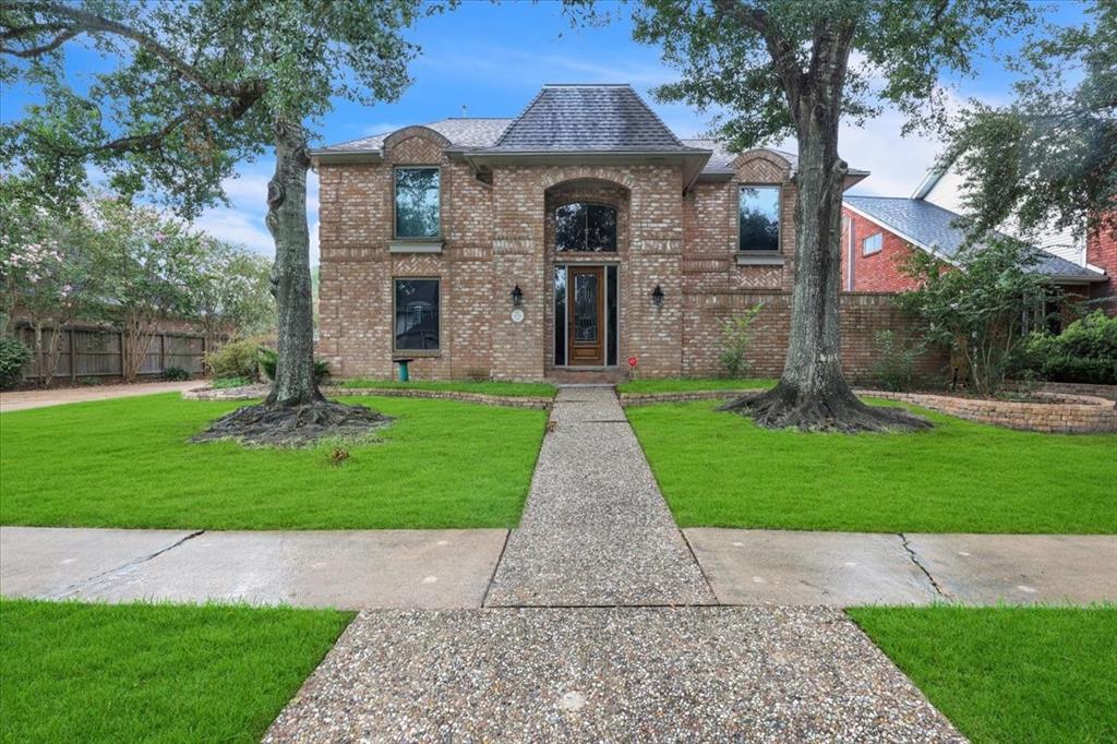 a front view of a house with a yard and garden