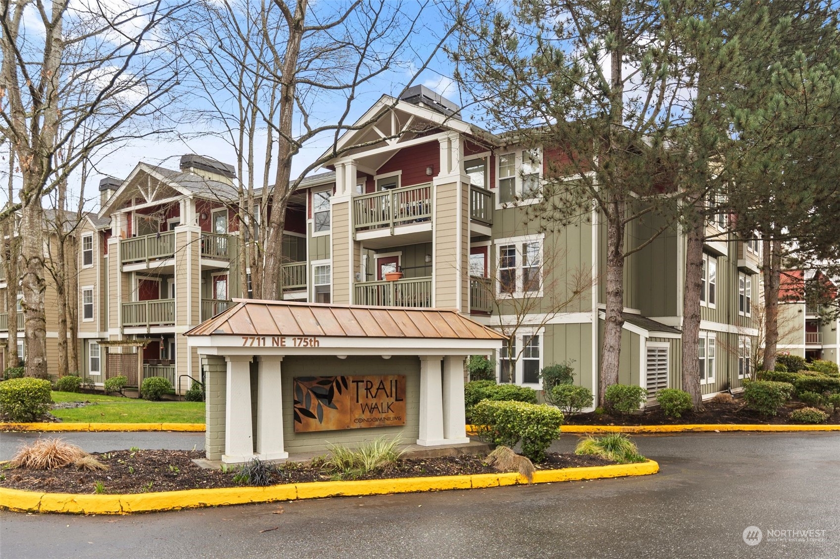 a front view of a residential apartment building with a yard and potted plants