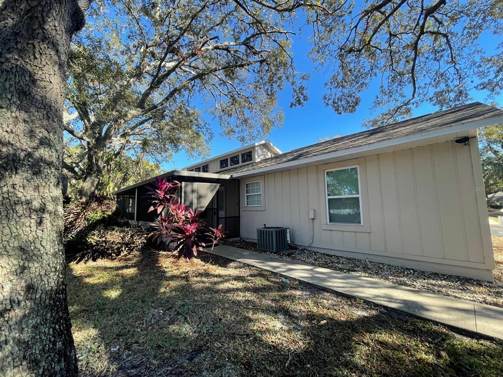 a view of a garage with a bench and a tree