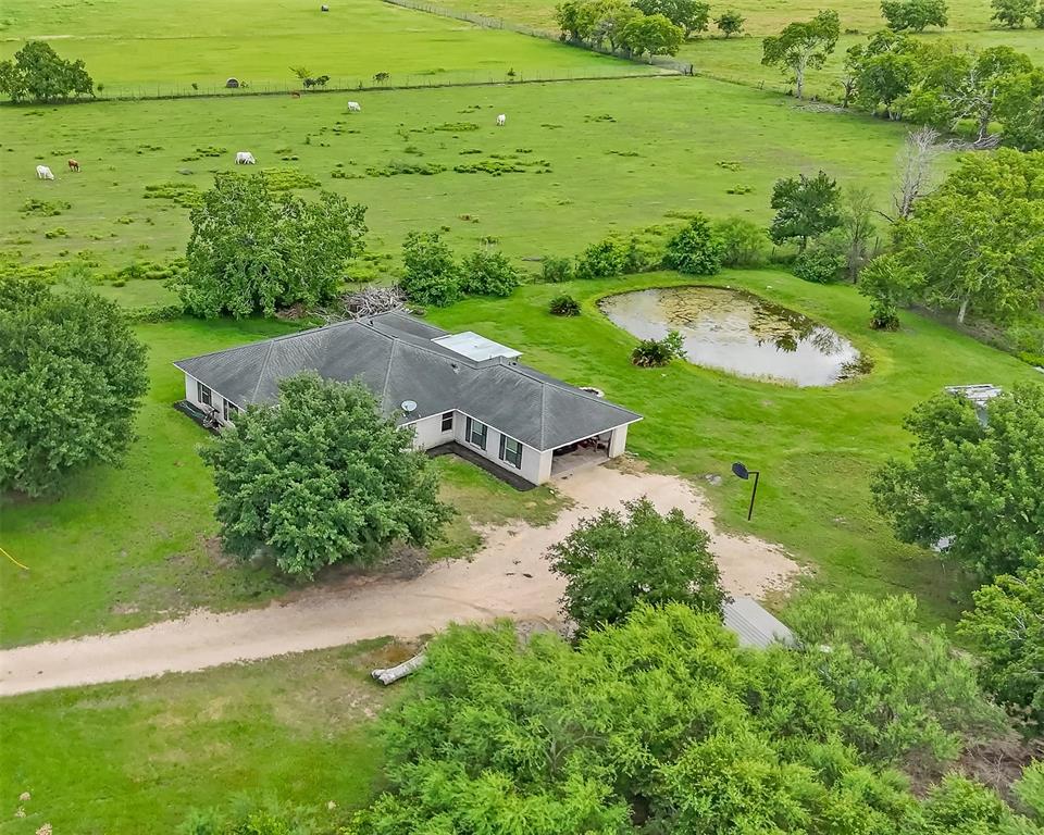 an aerial view of green landscape with trees houses and lake view