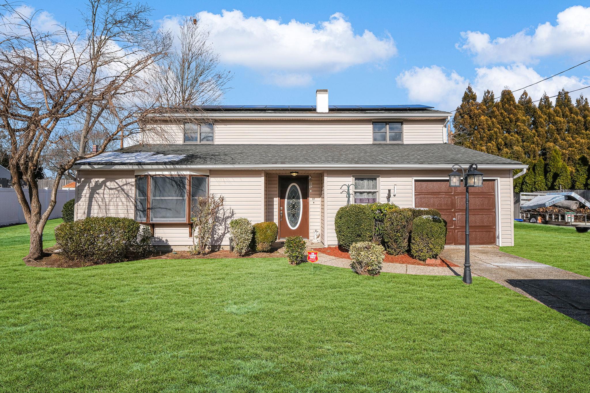 View of front of home with solar panels and garage