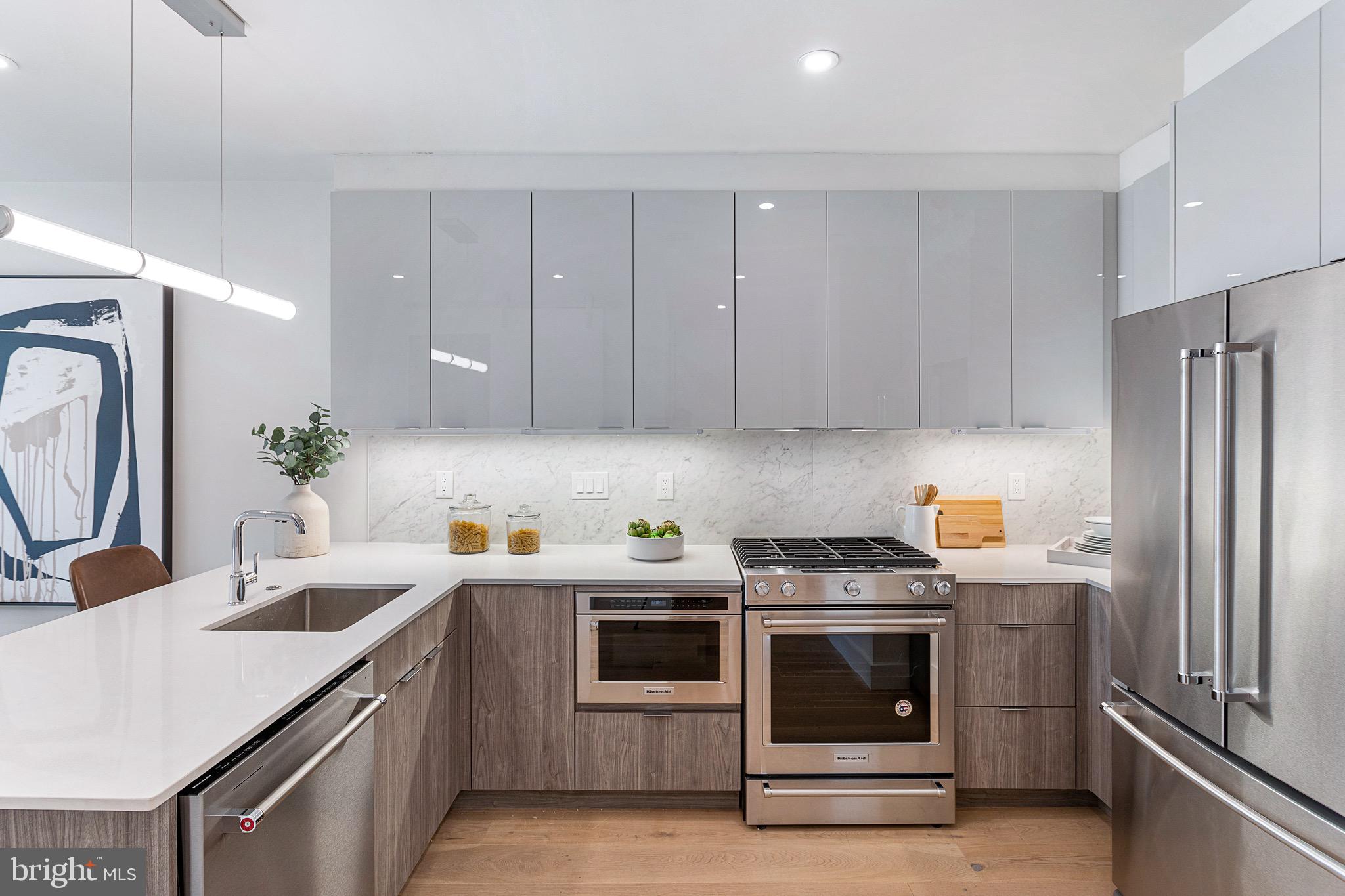 a kitchen with stainless steel appliances a stove a sink a refrigerator and cabinets