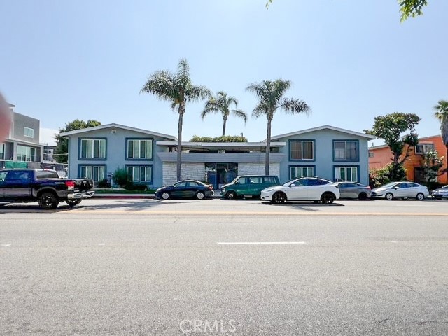 a front view of a building with cars parked