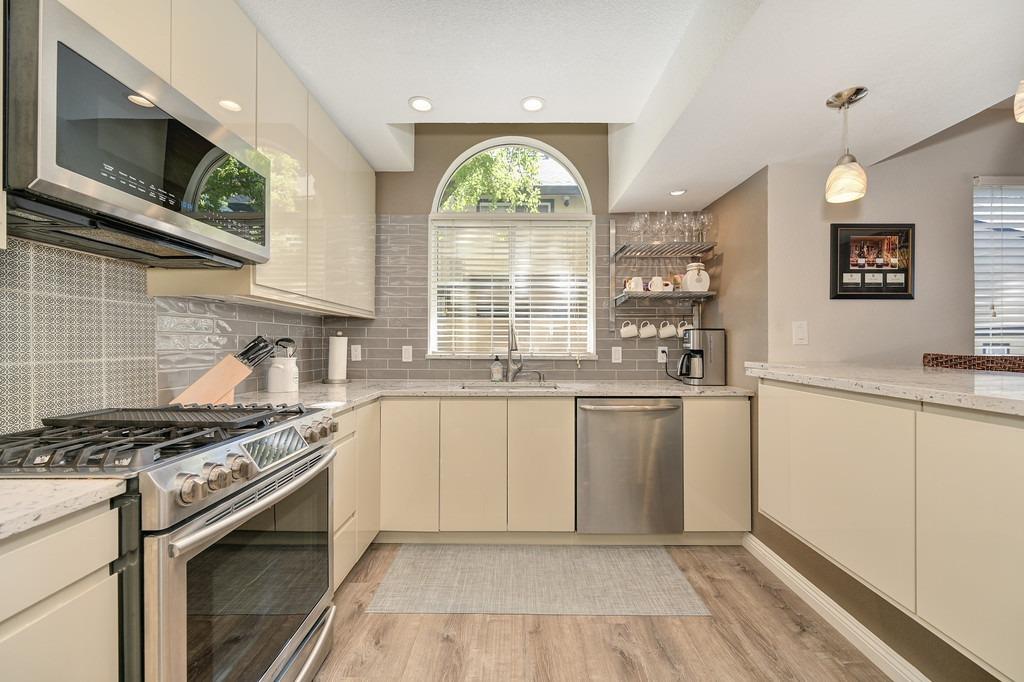 a kitchen with stainless steel appliances granite countertop a stove a sink and a granite counter tops