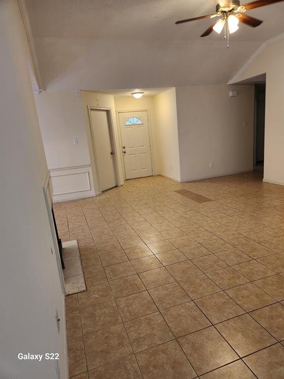 a view of an empty room and chandelier fan