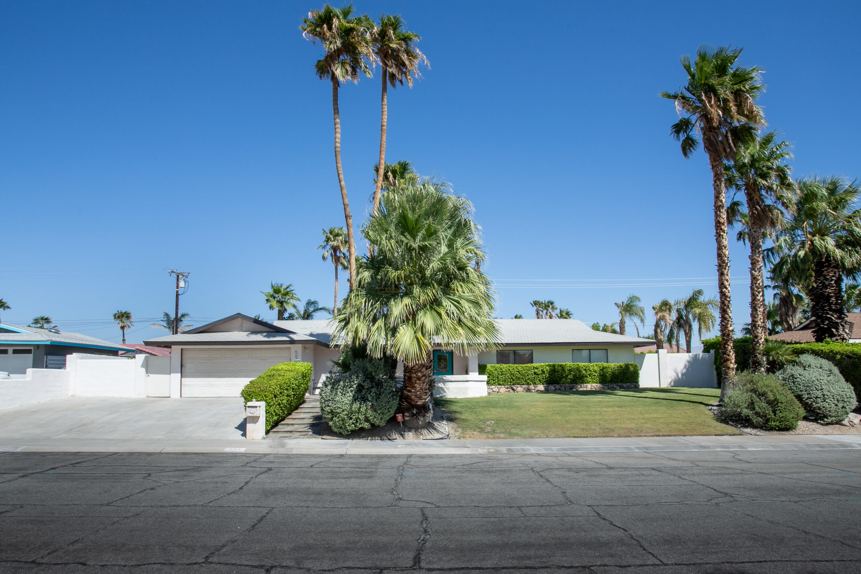 a front view of a house with a yard and potted plants