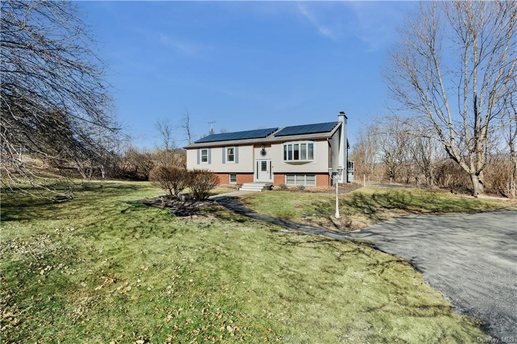 a view of house with yard and trees in the background