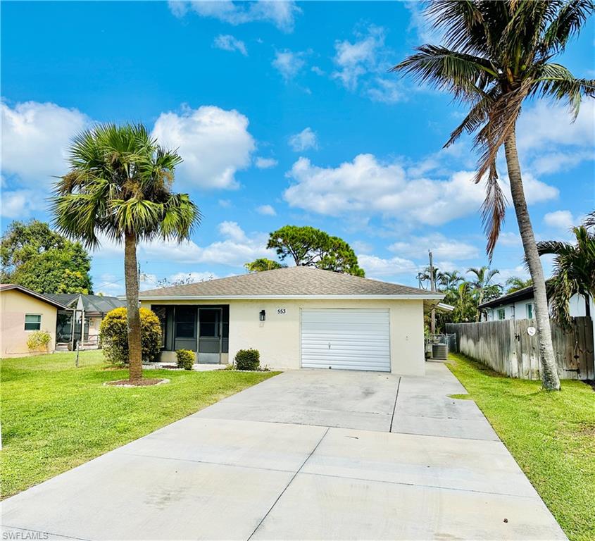 Ranch-style house featuring a front lawn, central AC unit, and a garage