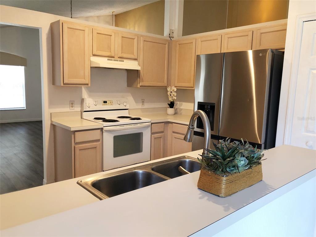 a kitchen with stainless steel appliances a stove a sink a refrigerator and cabinets