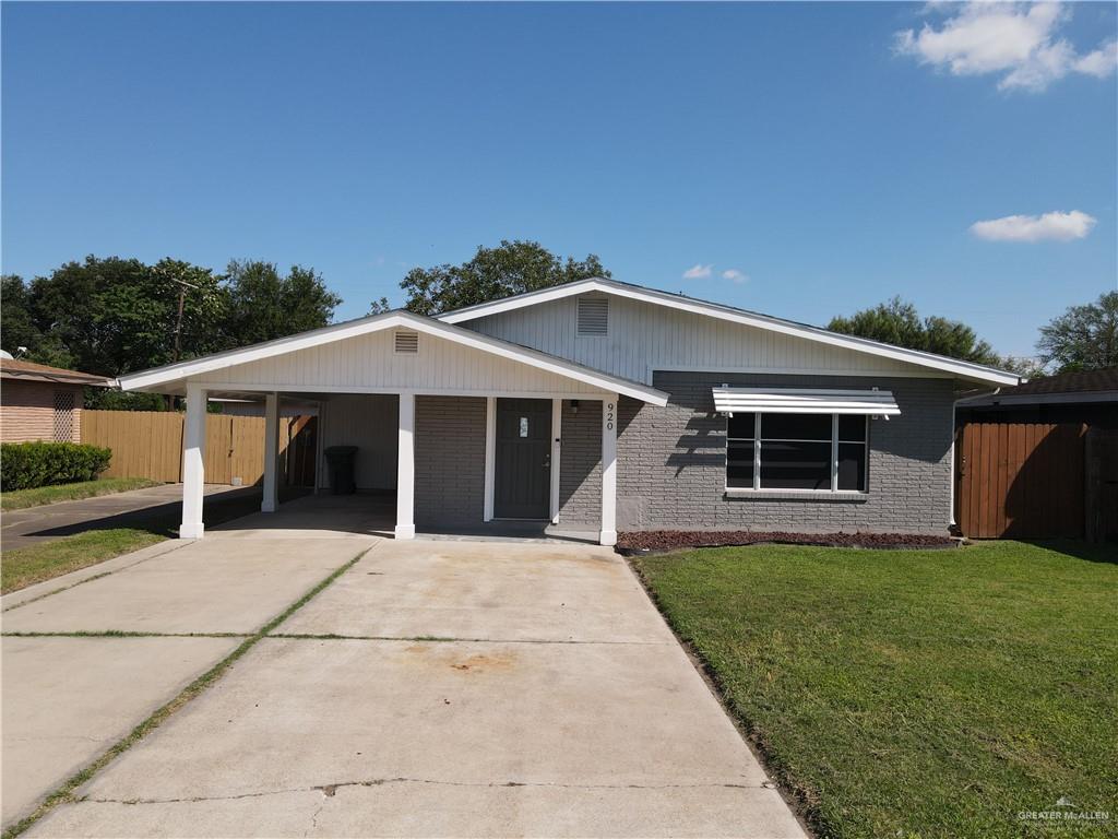 a front view of house with yard and trees in the background