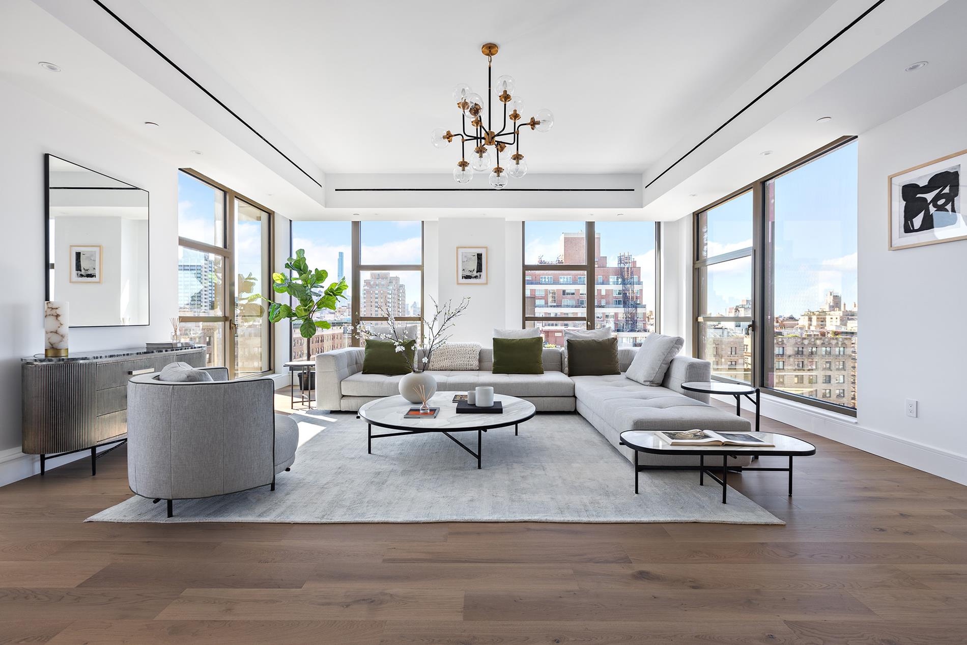 a living room with furniture a chandelier and a rug