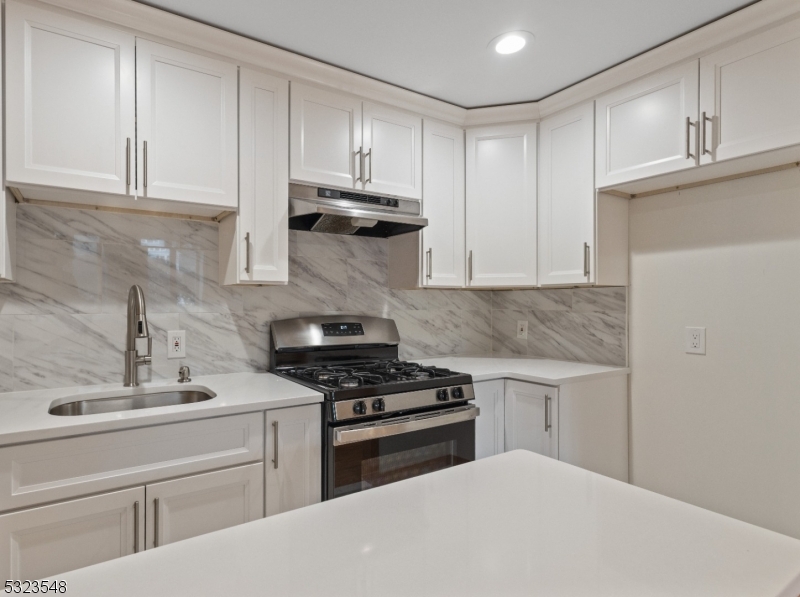 a kitchen with white cabinets and appliances