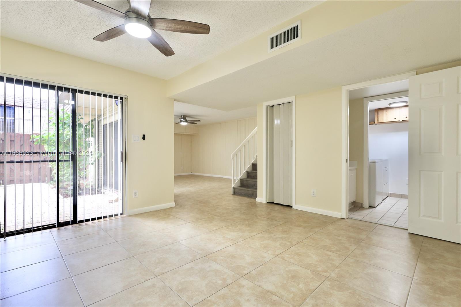 a view of empty room with window and ceiling fan