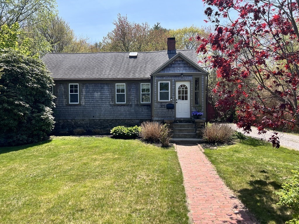 a front view of a house with yard and green space