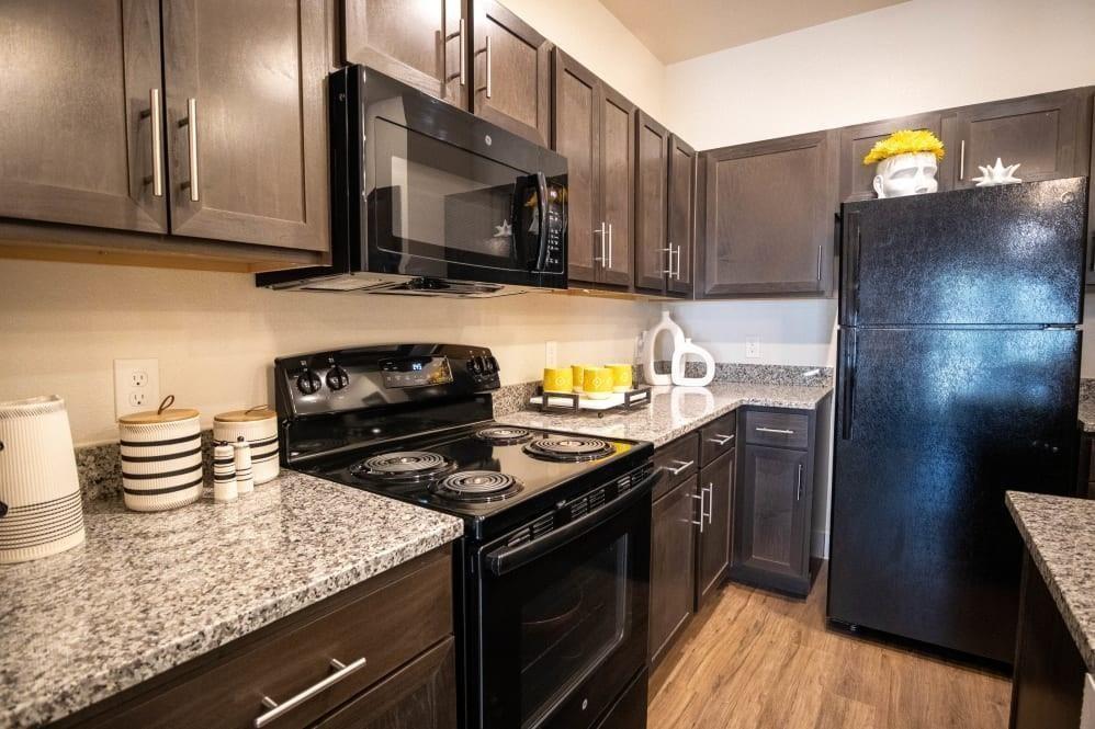 a kitchen with granite countertop a stove and a wooden floor