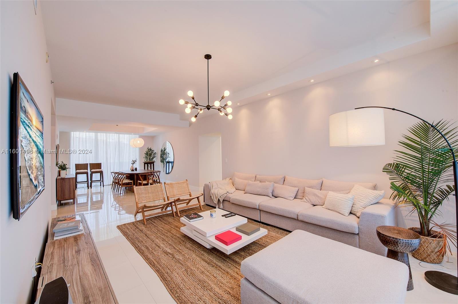 a living room with furniture chandelier and a table