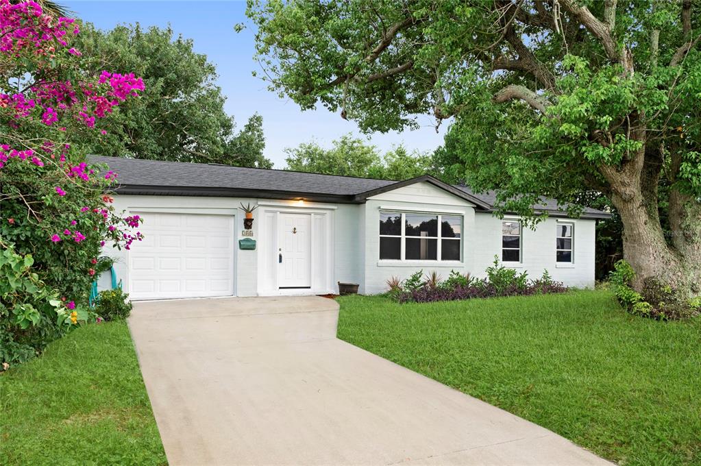 a front view of a house with a garden and trees