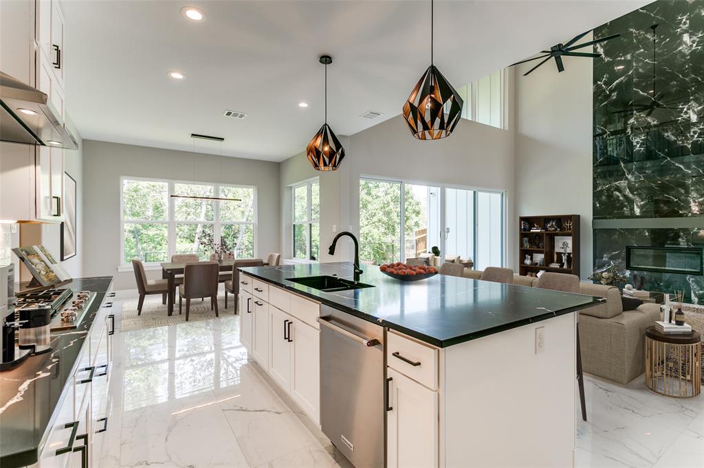 a kitchen with stainless steel appliances granite countertop a sink a stove and a refrigerator