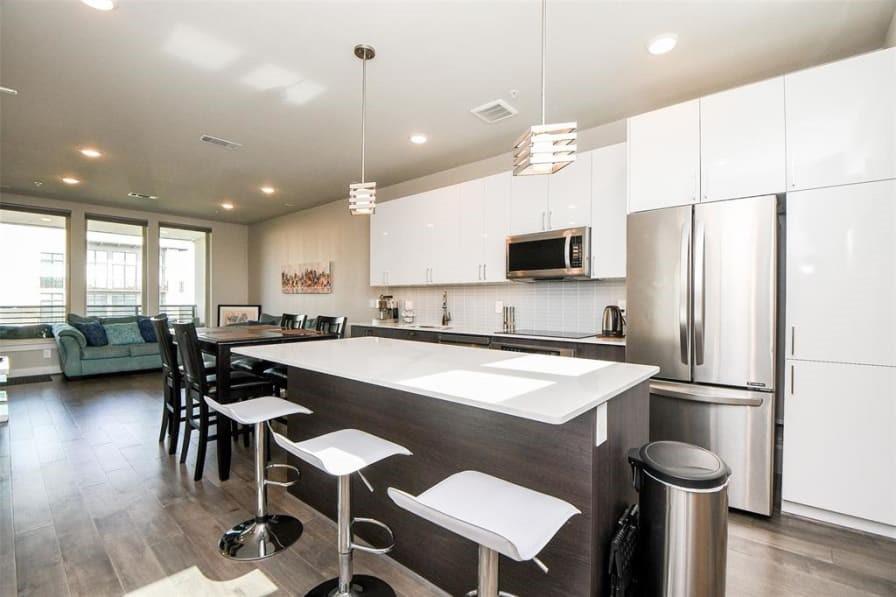 a kitchen with a table chairs refrigerator and microwave