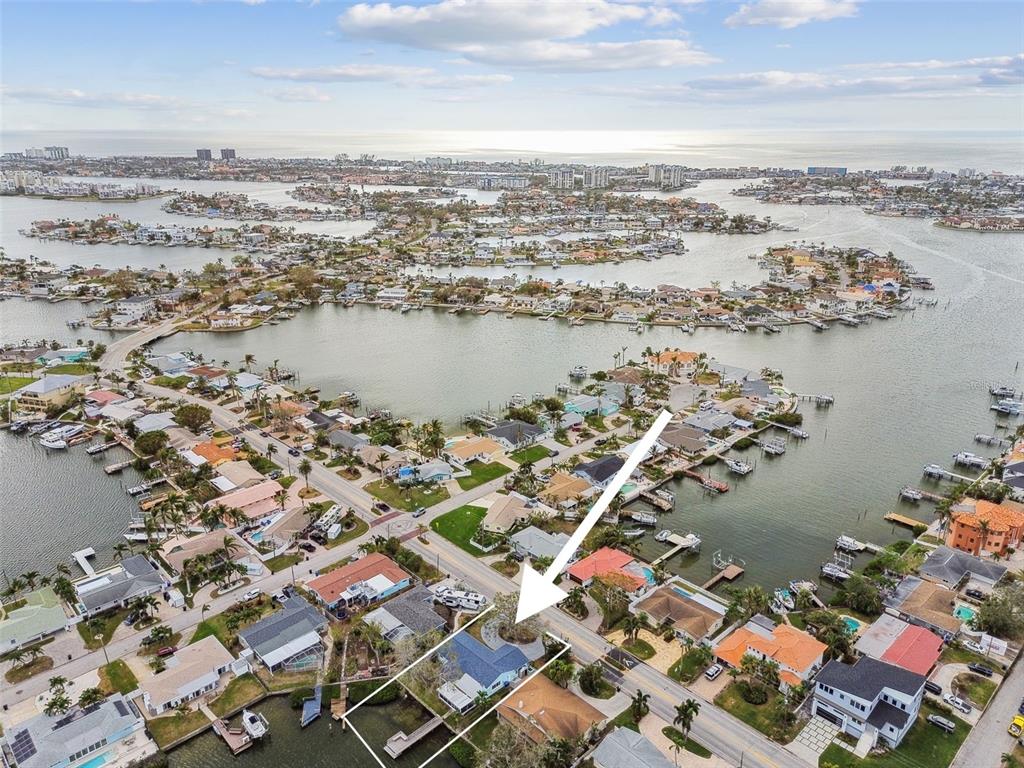 an aerial view of ocean and residential houses with outdoor space