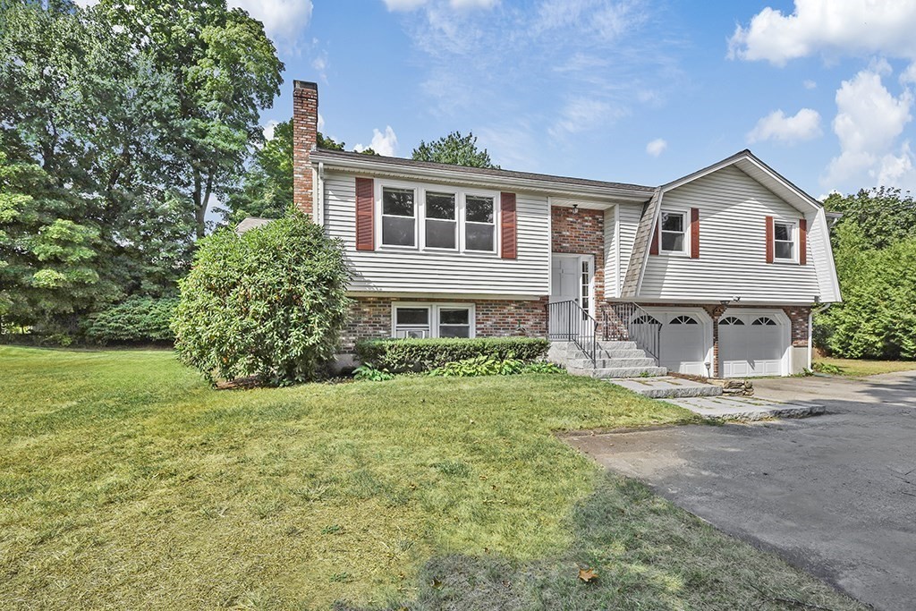 a front view of house with yard and green space