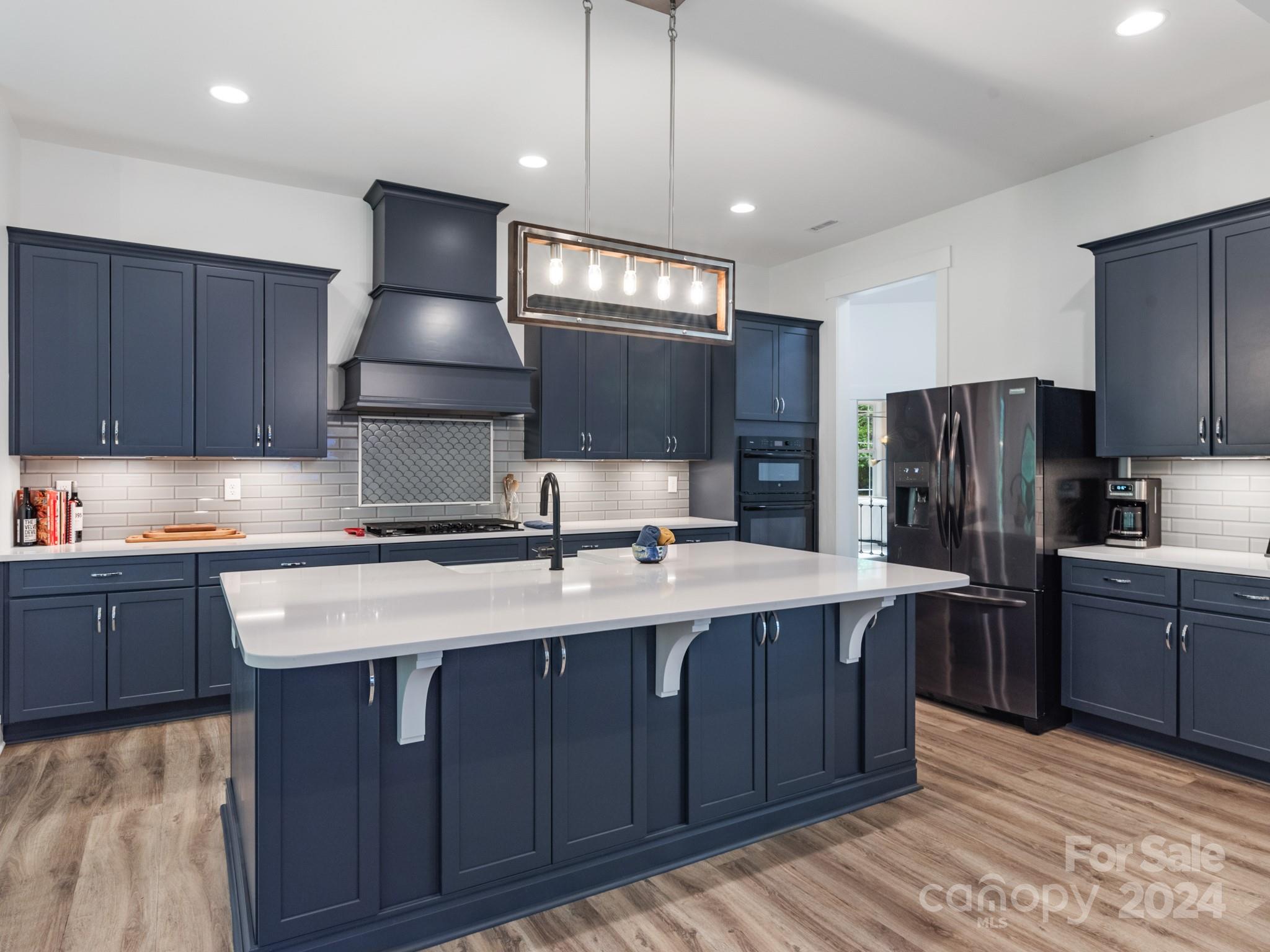 a kitchen with stainless steel appliances granite countertop a sink a stove and a refrigerator