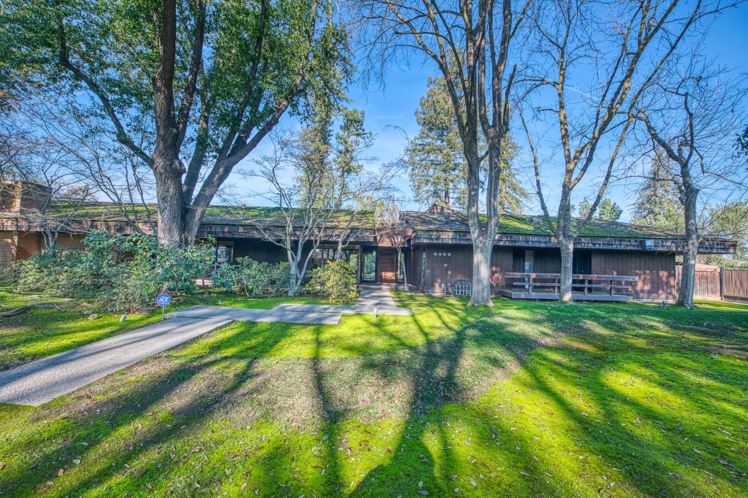 a view of a house with pool and trees in the background