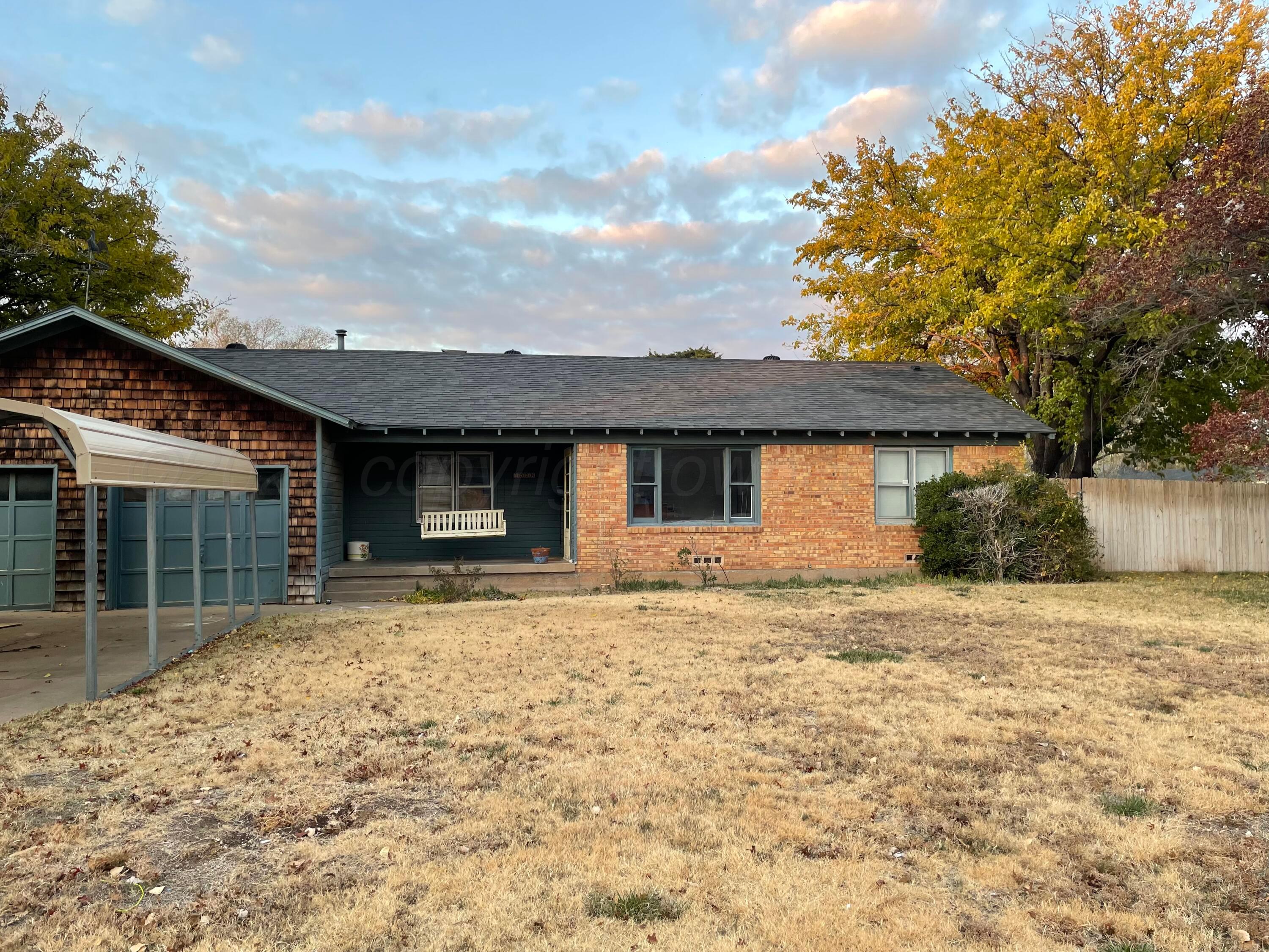 a front view of a house with a garden and yard